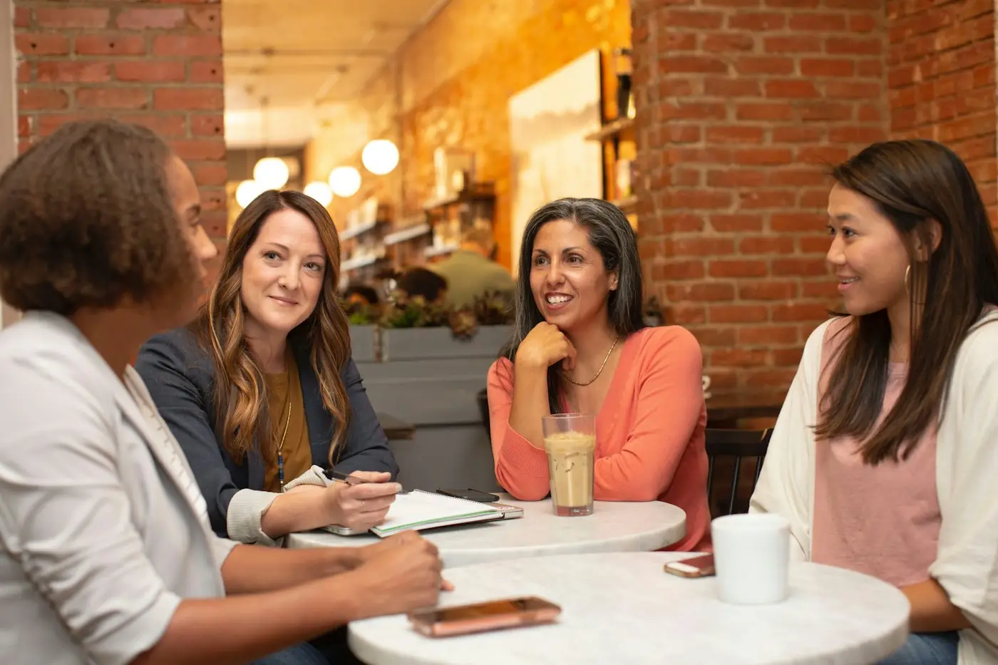 Four women talking around a cafe table