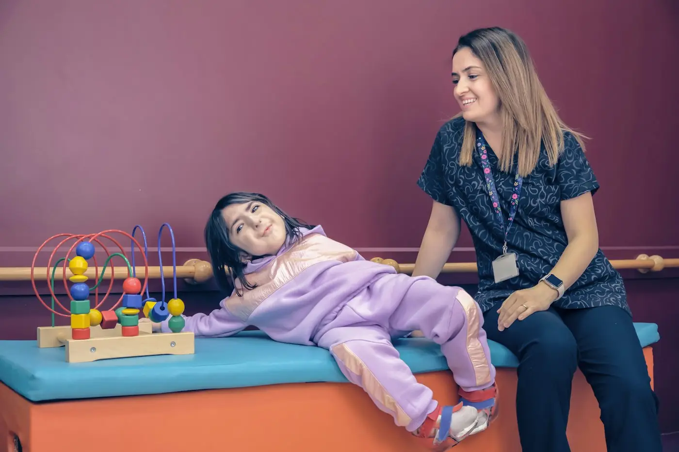 Support worker sitting with a young girl in a calm sensory room