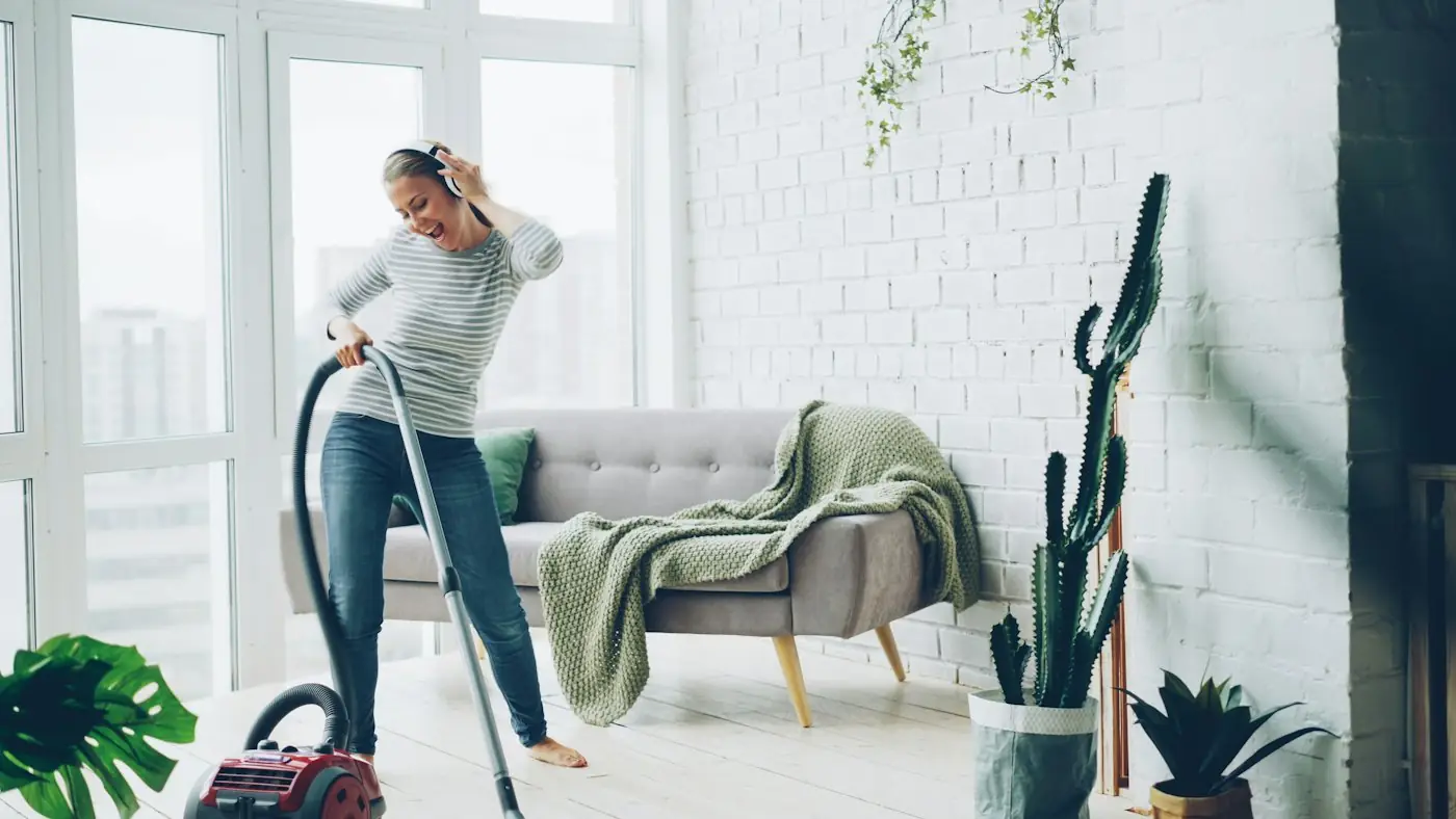 Woman vacuuming a bright, tidy living room