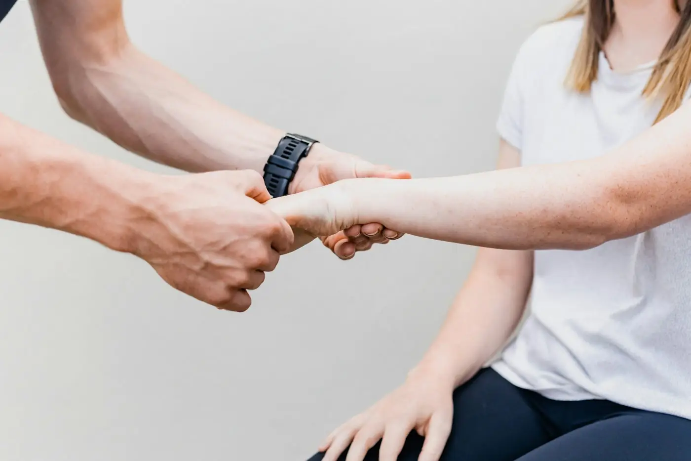 Two people's hands clasped together in support