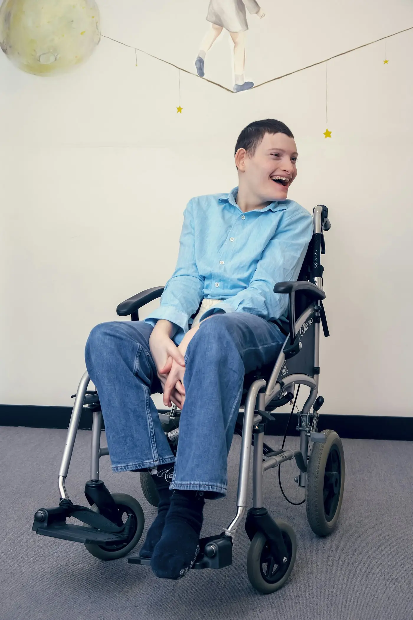 Smiling young man in a wheelchair indoors