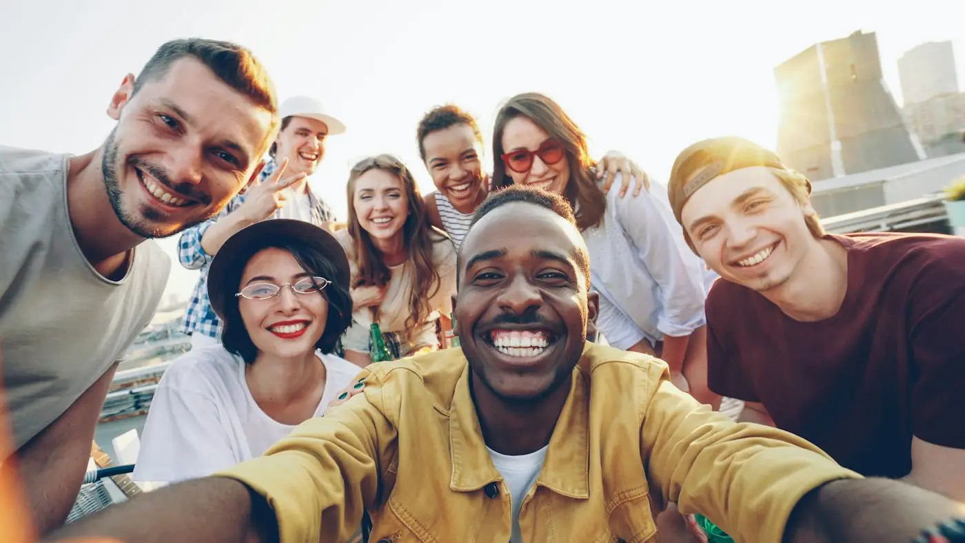 Diverse group of young adults smiling together outdoors